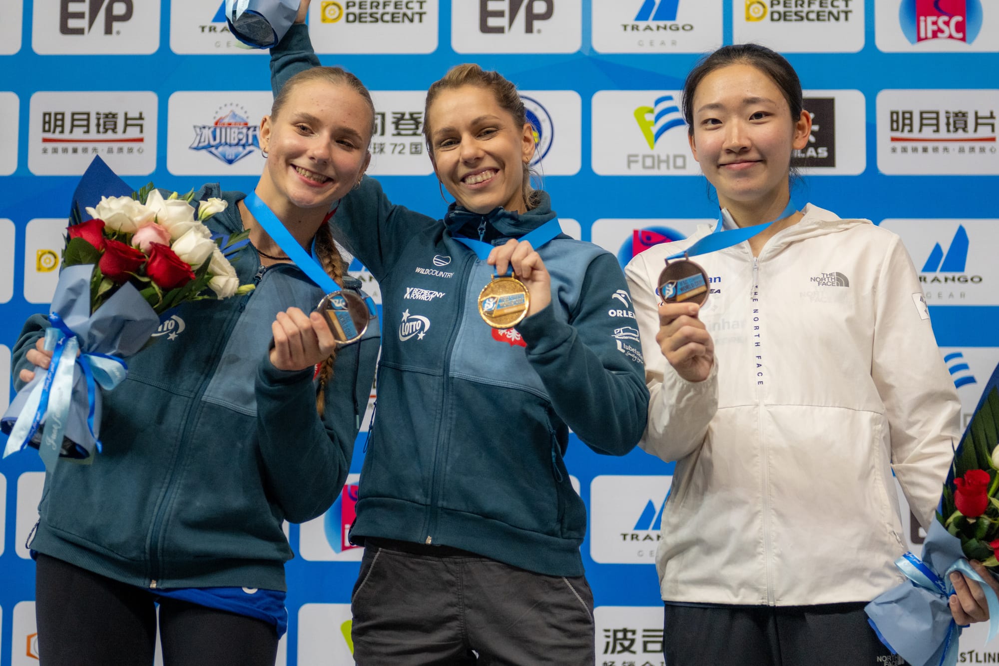 The women's podium: Ola Miroslaw, Natalia Kalucka, and Jimin Jeong celebrating with their medals.