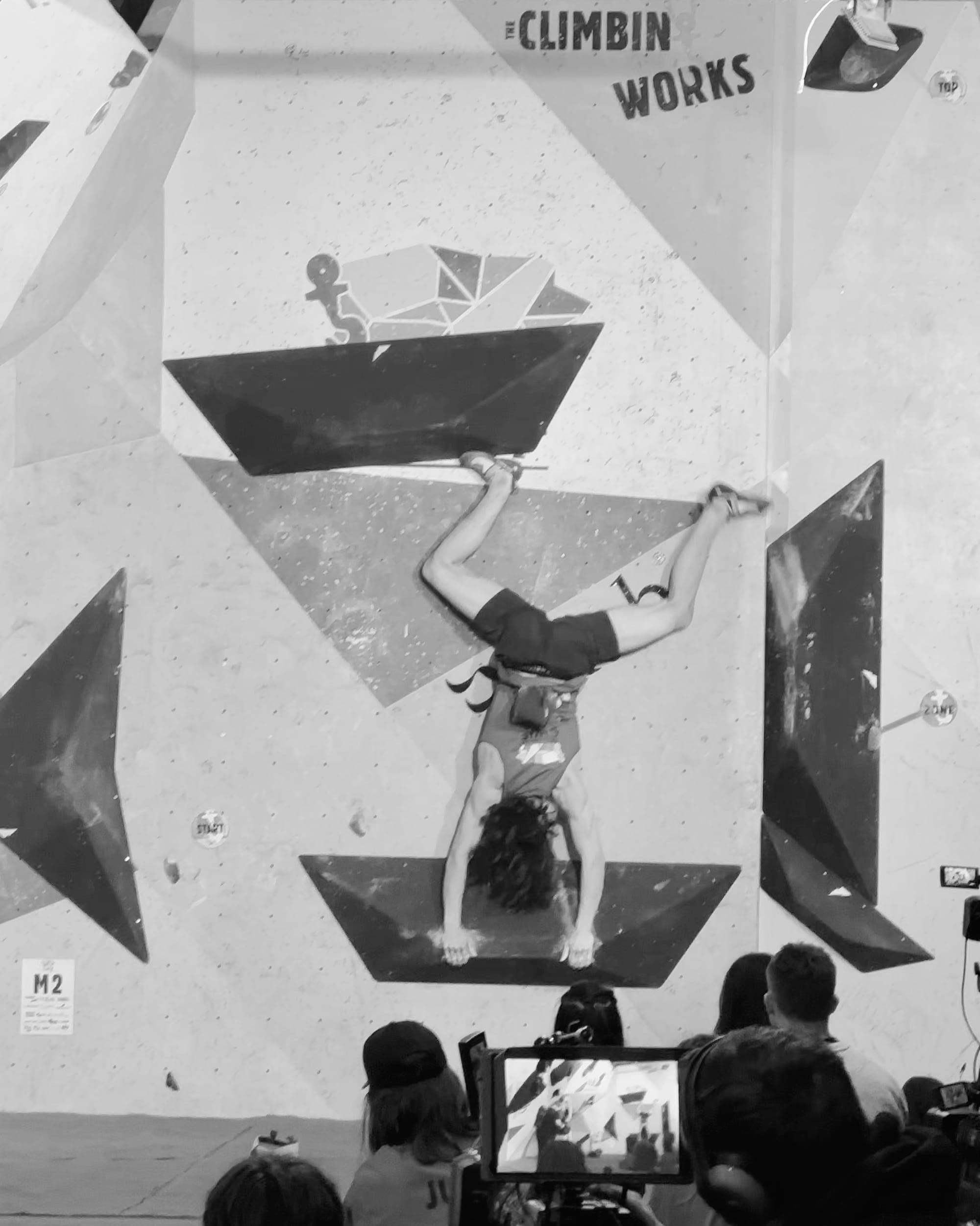 Jack MacDougall upside down on the M2 "cartwheel" boulder in the final of CWIF 2024